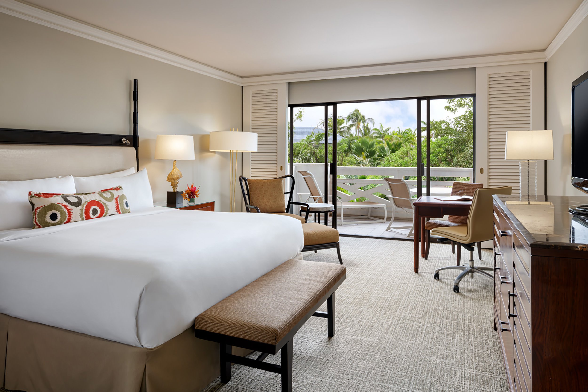 bedroom with sitting area and balcony overlooking the property gardens