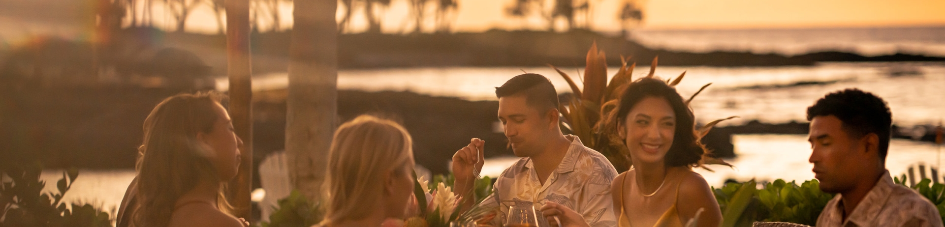 a group of people eating outside at sunset