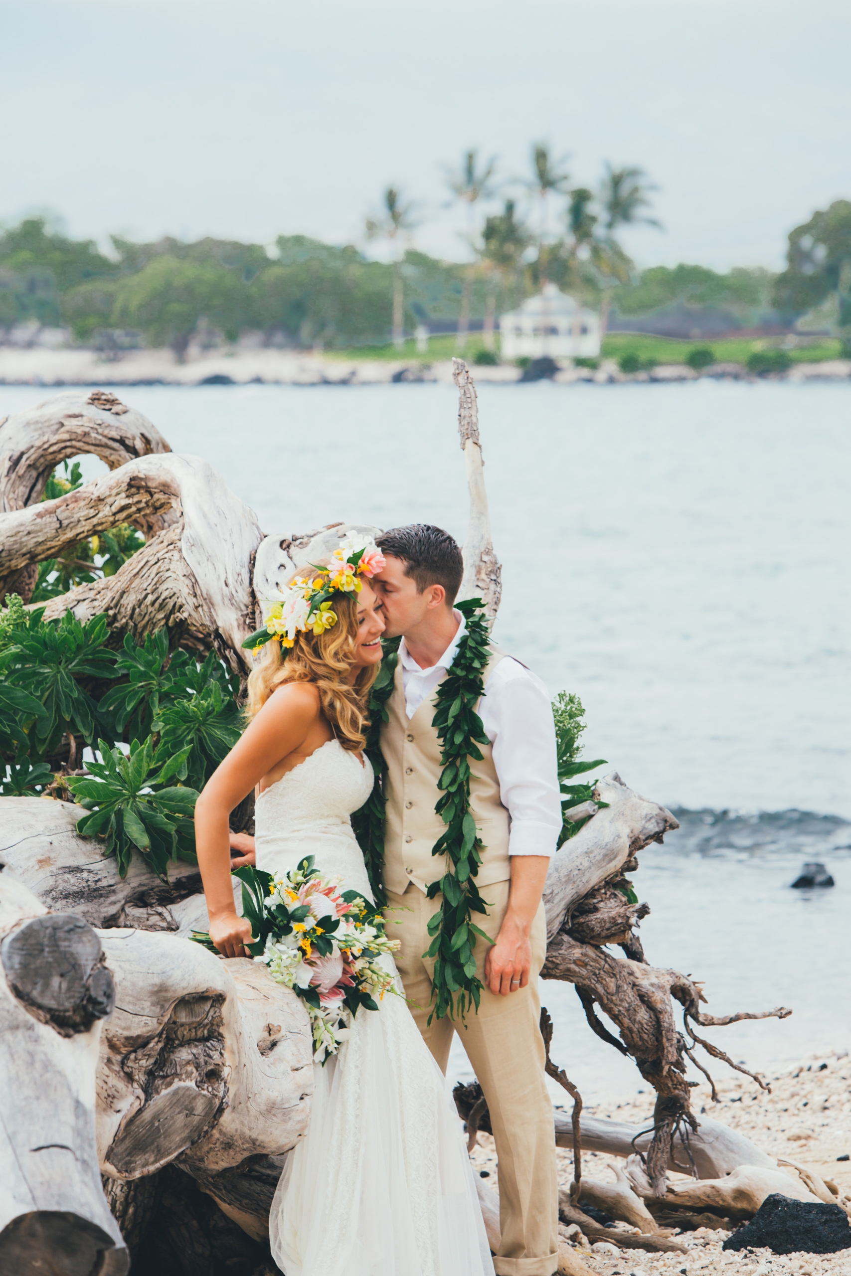 a bride and groom posing on the beach