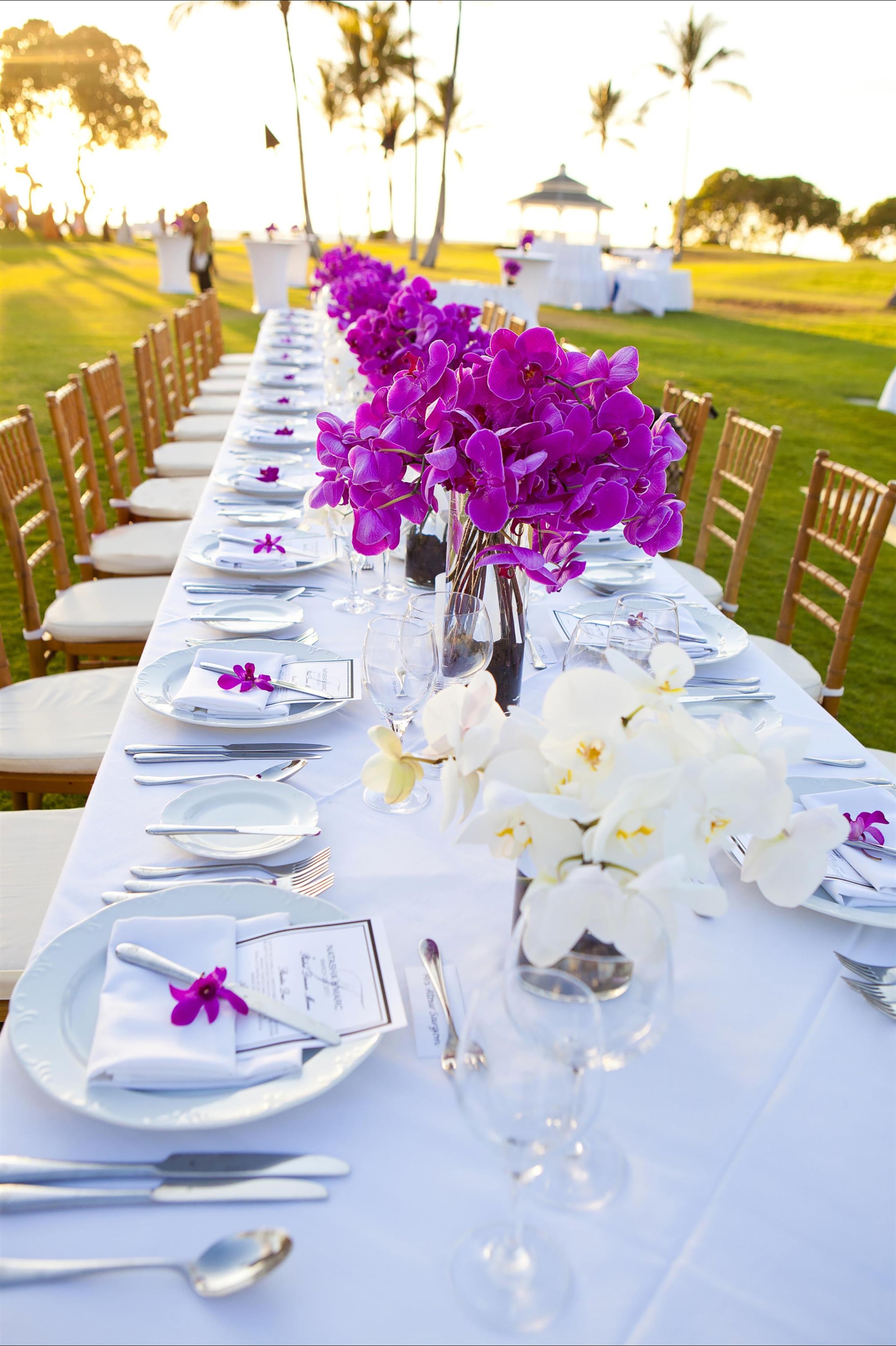 long dinner table set up with bright pink glowers