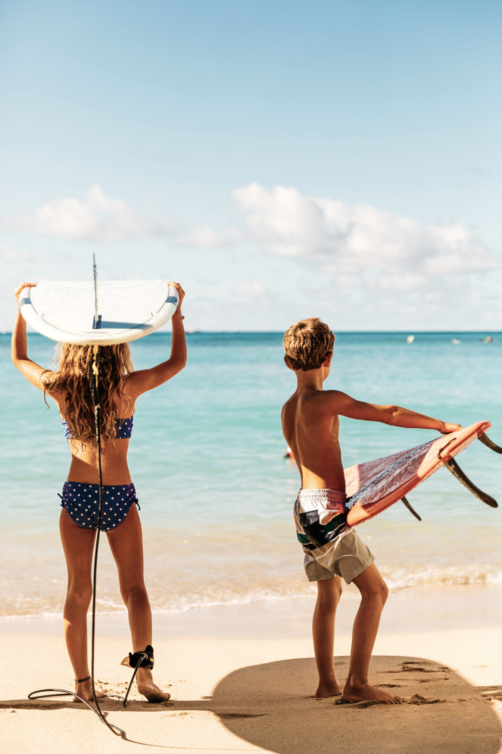 kids holding surf boards