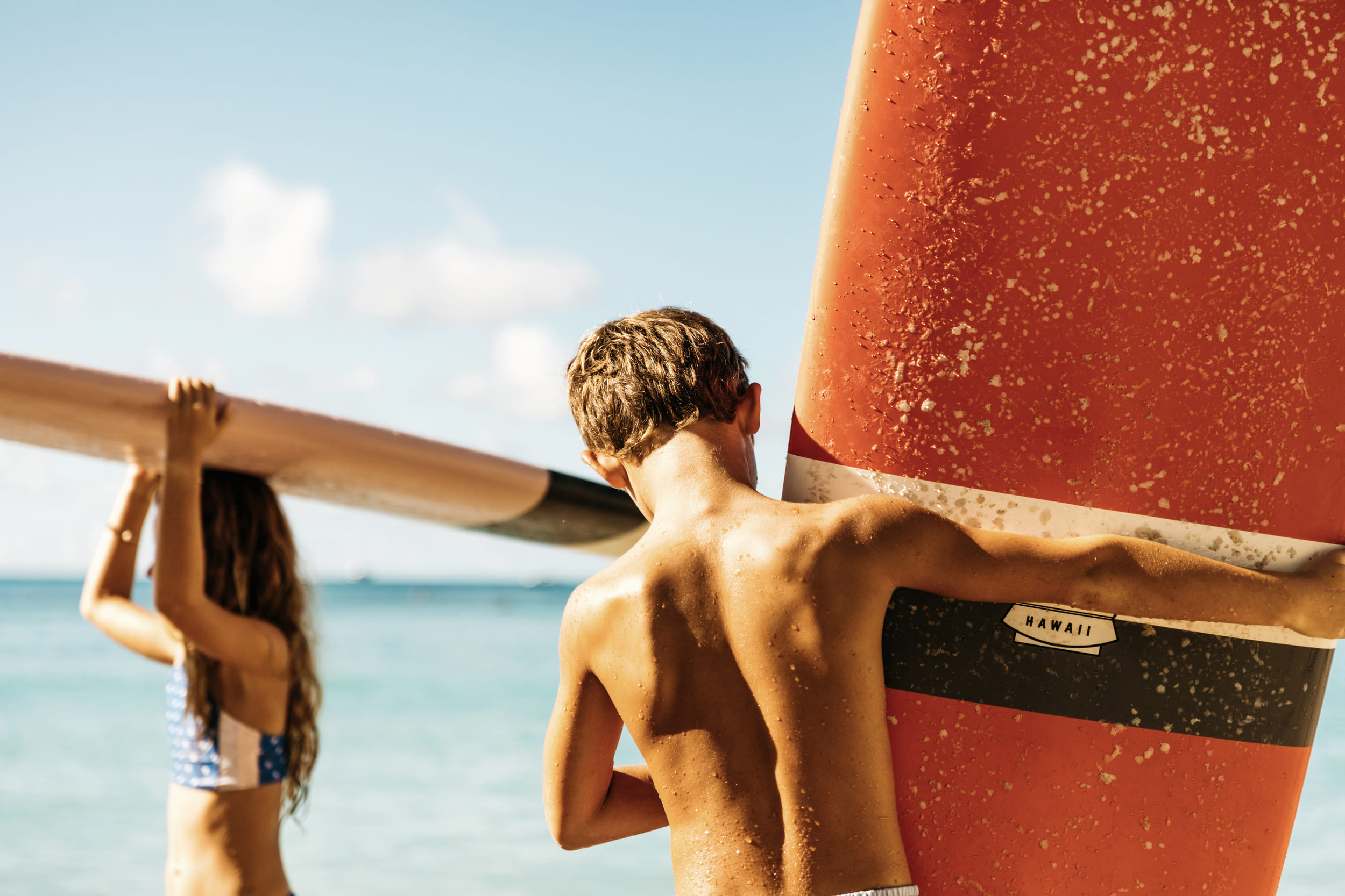 kids holding surf boards