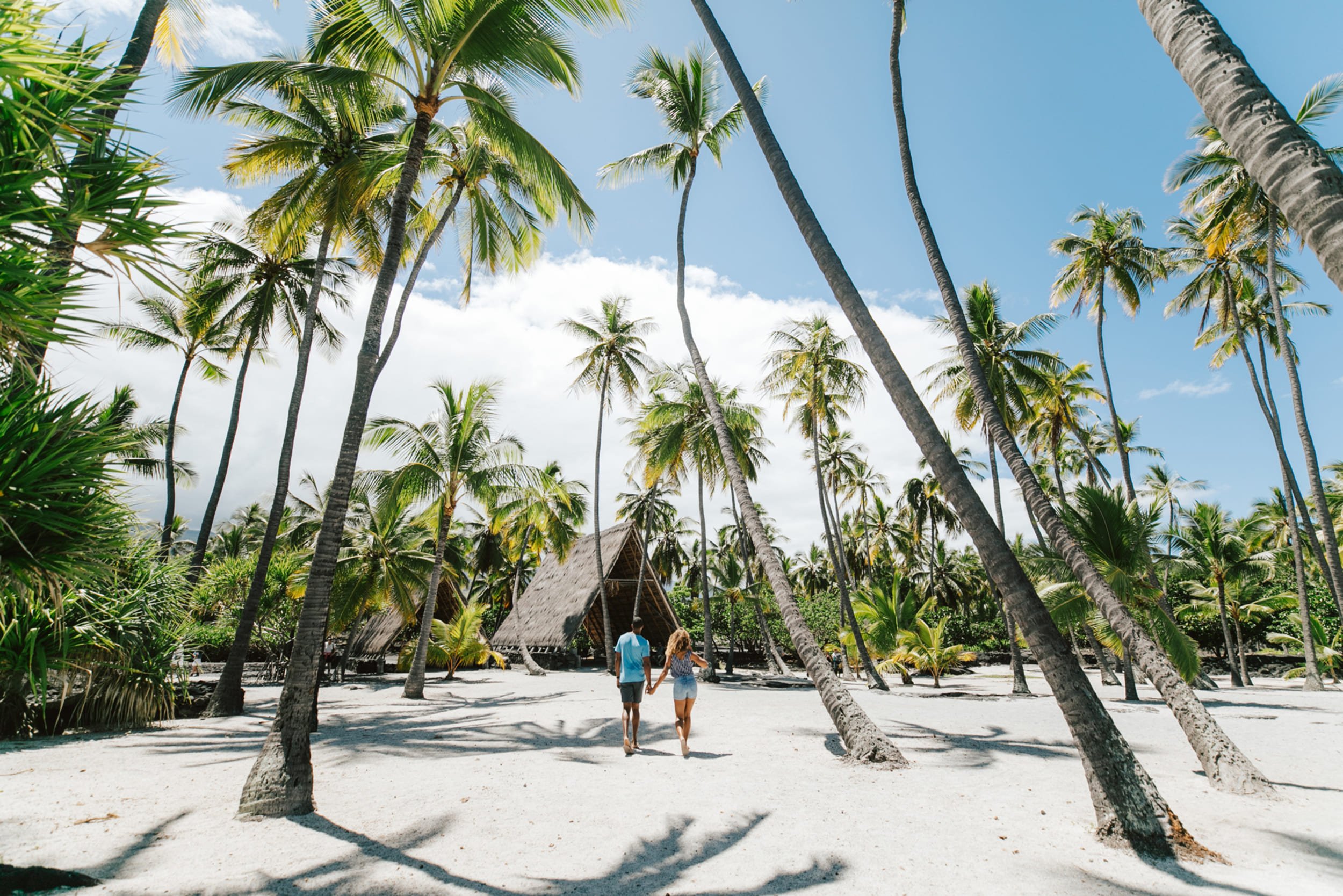 two people walking towards a hut