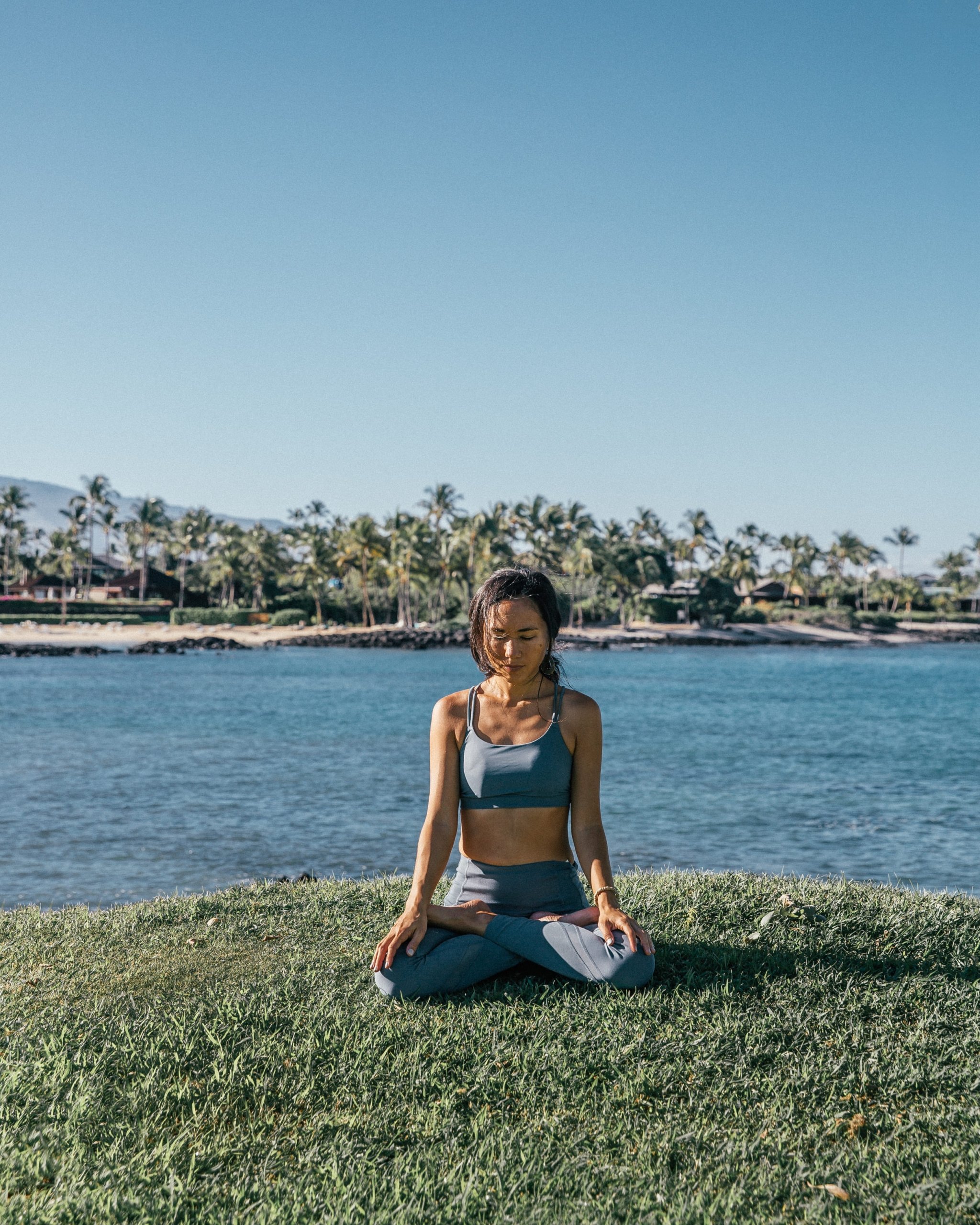 woman doing yoga by the ocean