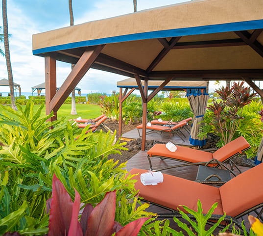 two cabanas with lounge chairs