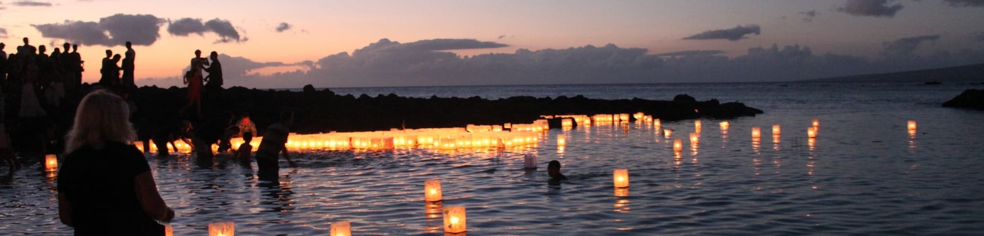 people placing floating lanterns on the water