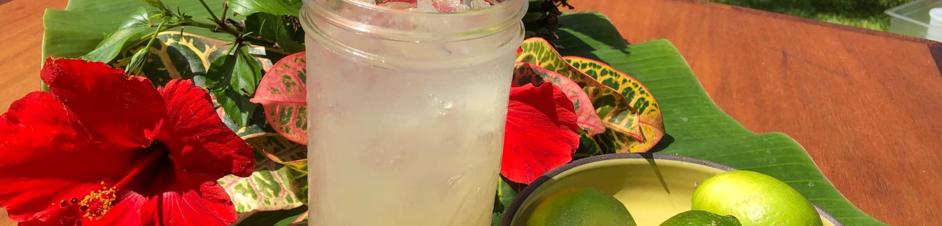 glass of limeade with plate of limes