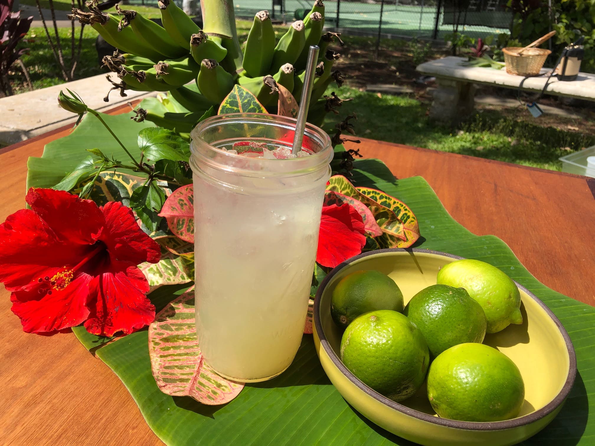 glass of limeade with plate of limes