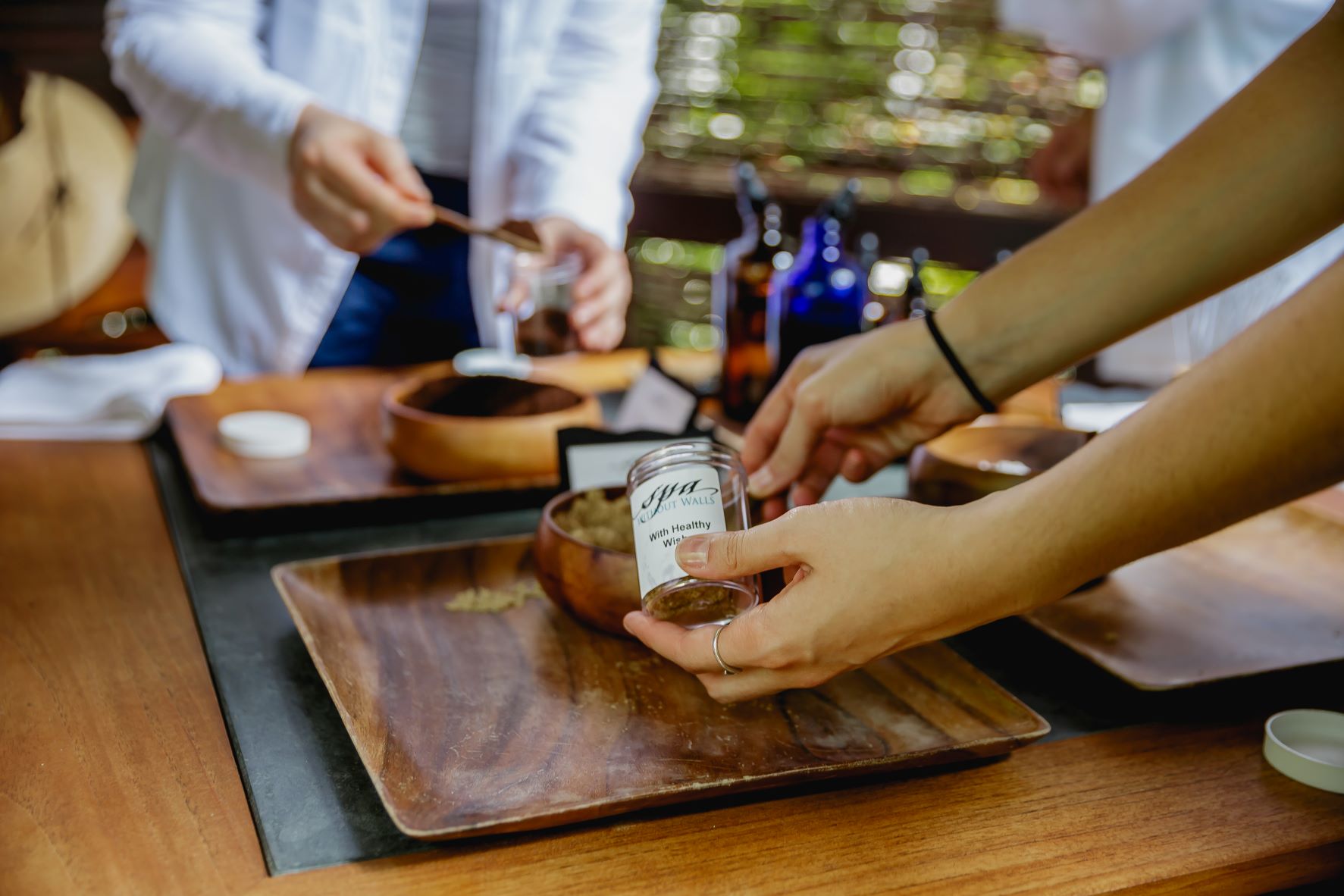 Hands scooping salt into jar