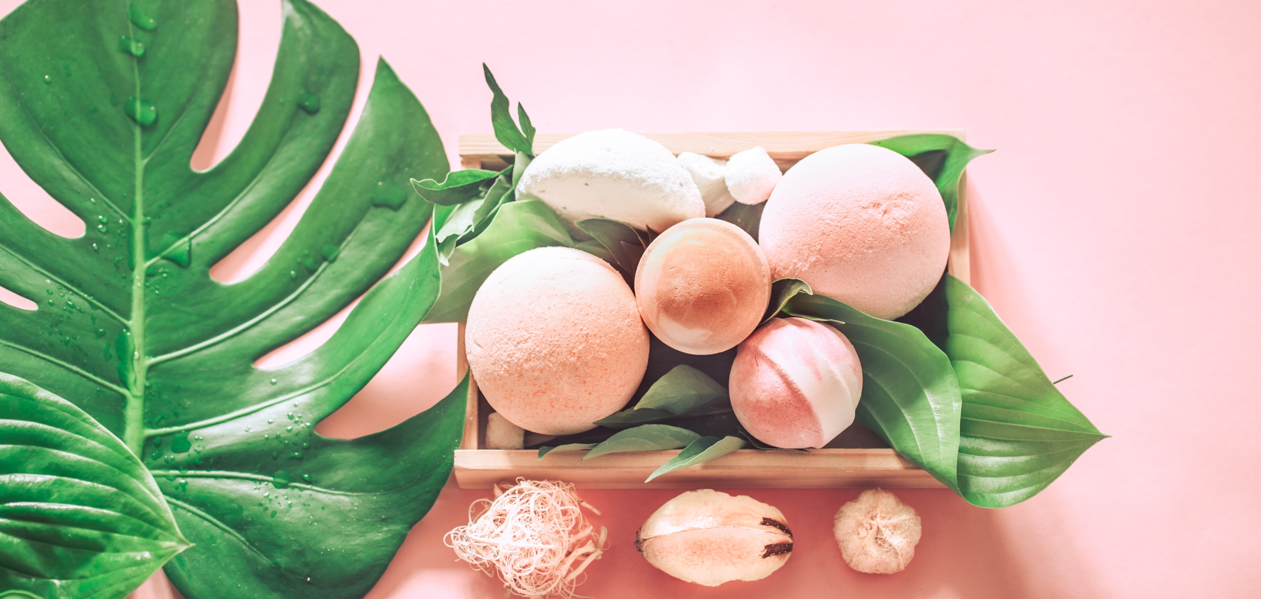 salt bombs for a spa bath still life on a colored background with tropical real leaves