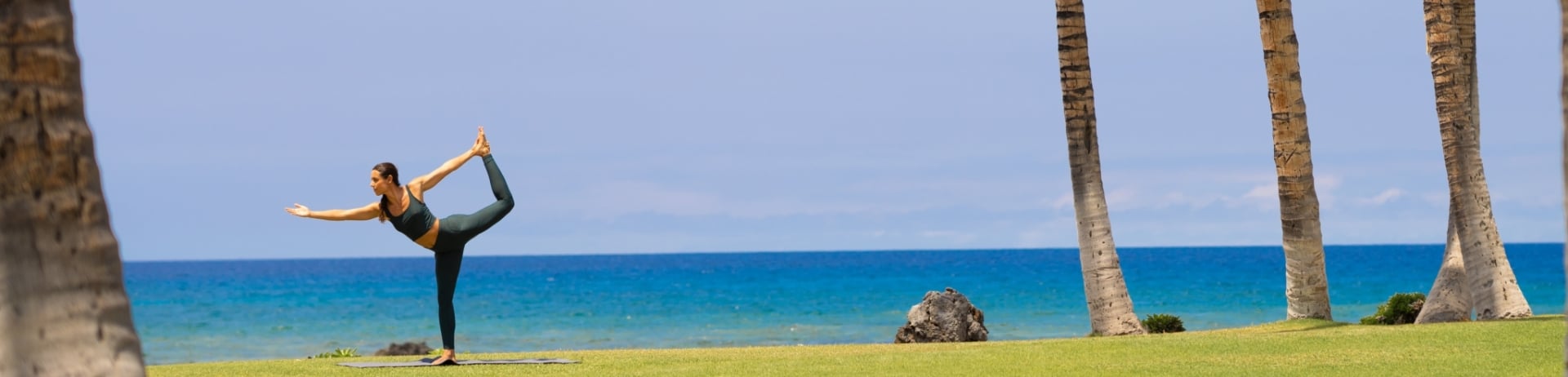 Woman doing yoga by the ocean-wide shot